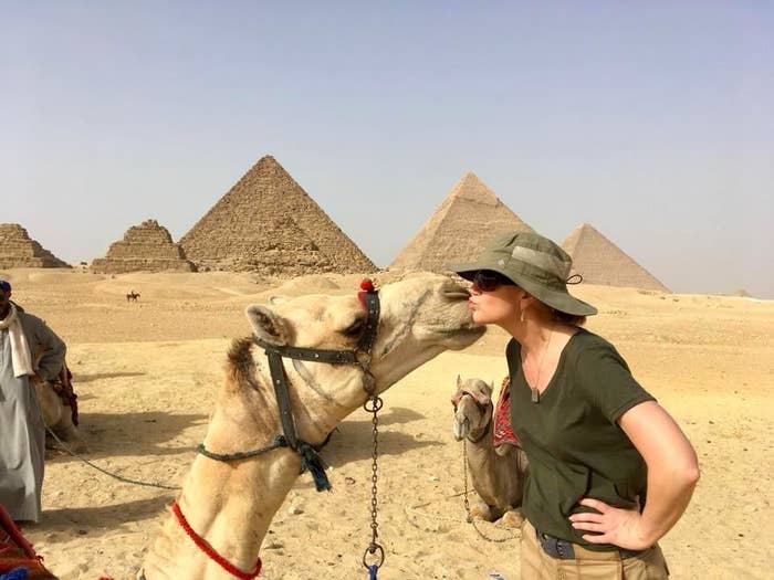 Reviewer wearing green hat and kissing camel