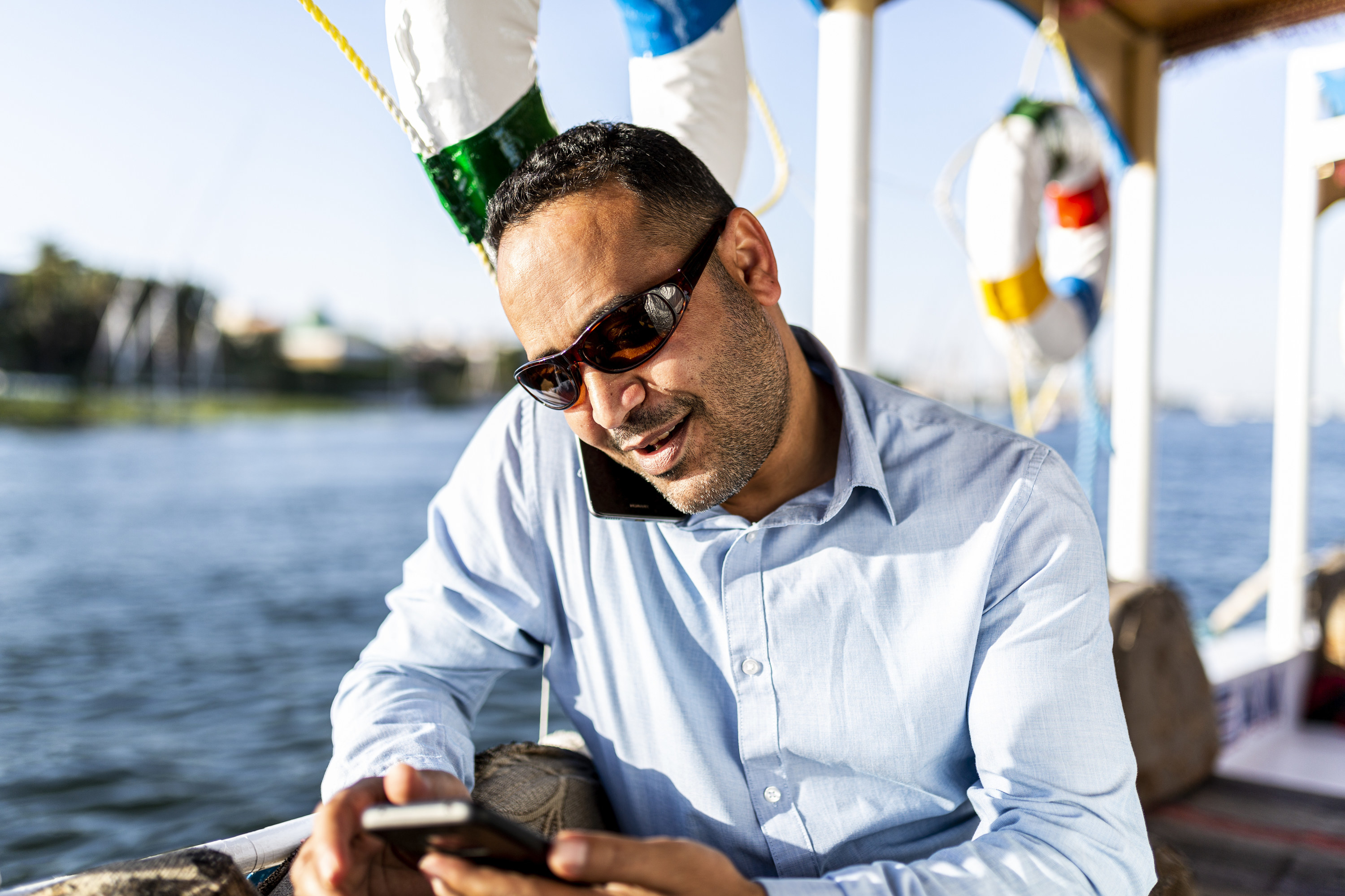 a man using his shoulder to hold up. phone