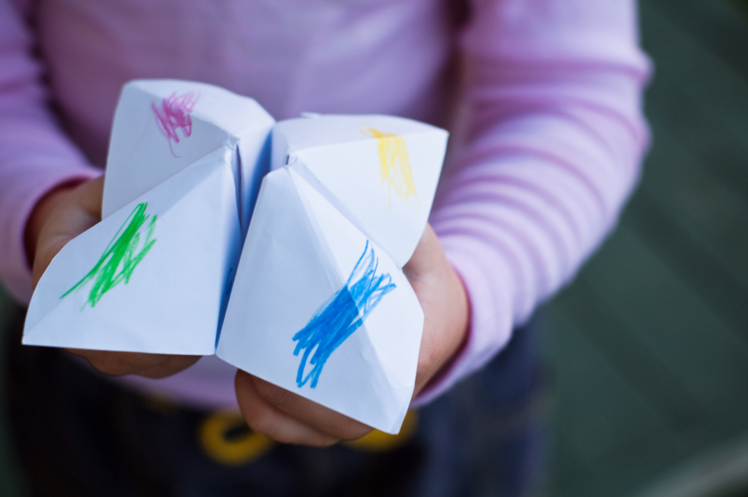 a kid with a  paper fortune tellers