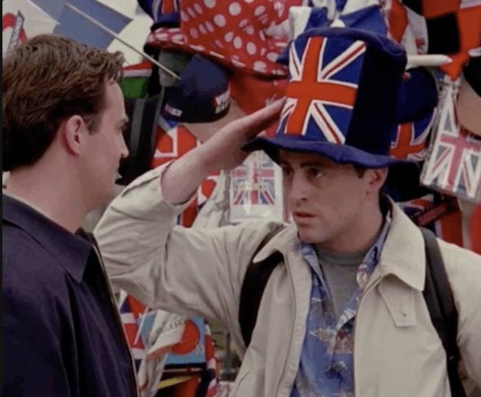 乔伊从朋友指着他的英国的帽子