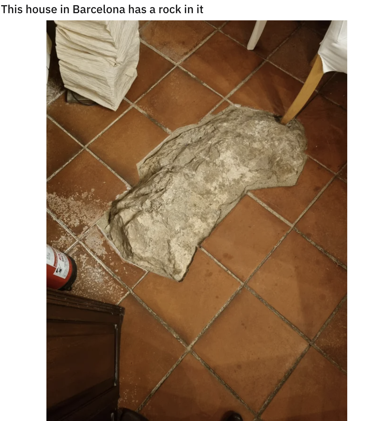 large rock exposed through the tile of the floor