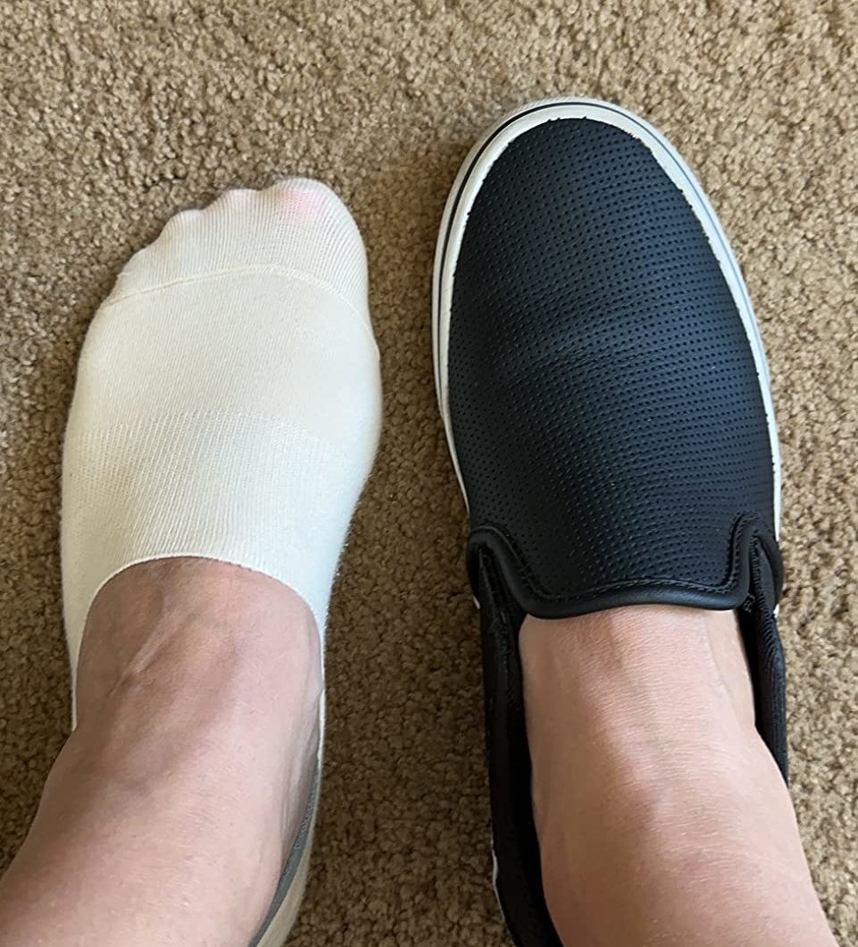 Reviewer&#x27;s left foot with white no-show sock while right foot shows black slip on sneaker on foot with no sock visible