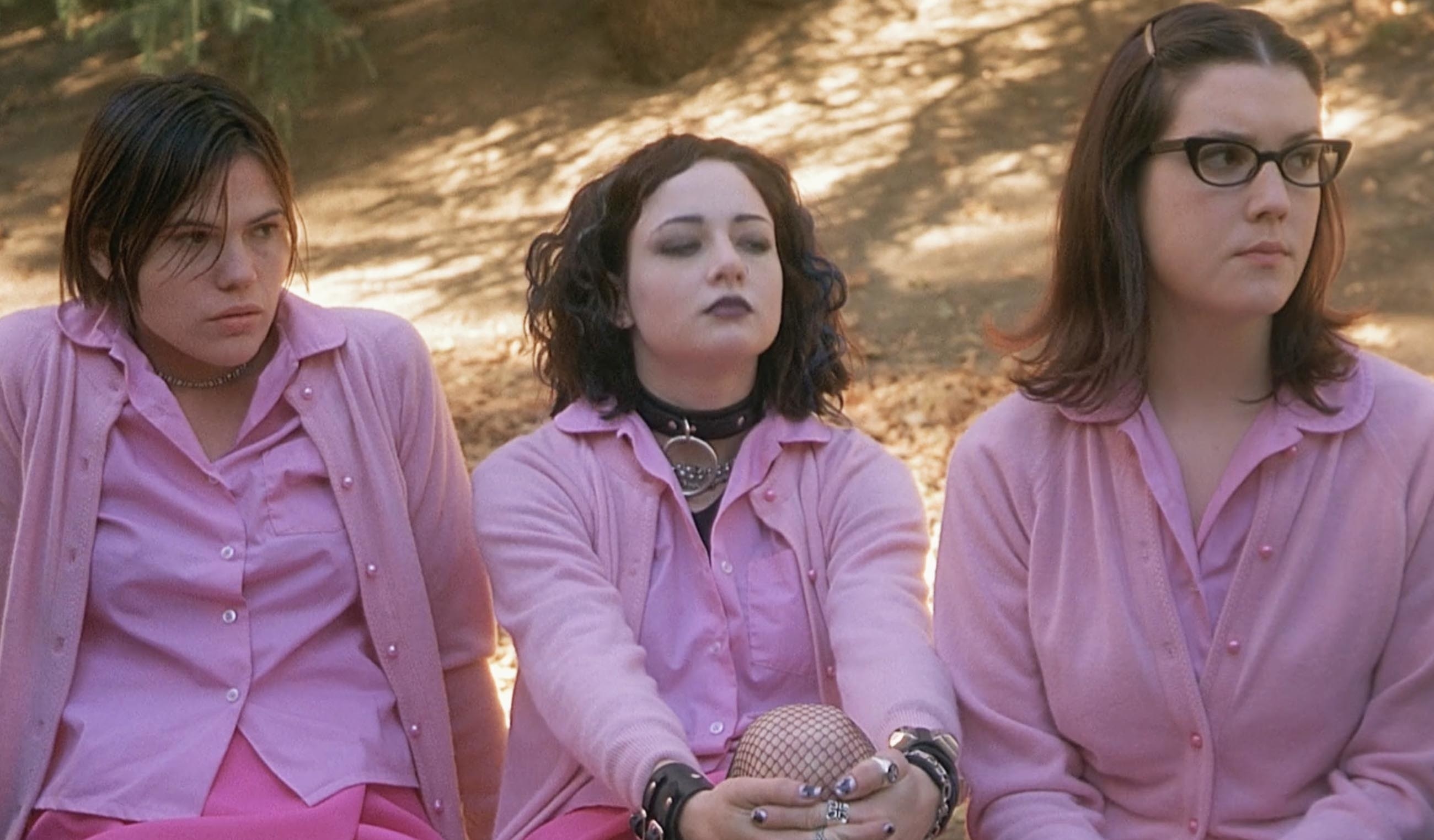 three women sitting outside in the same uniform