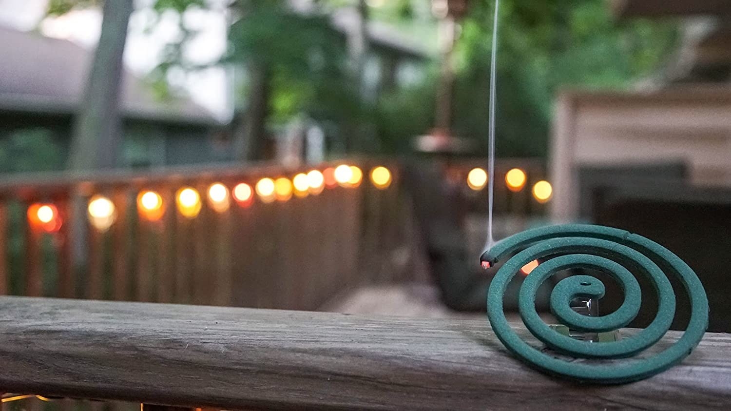The lit coil on wooden deck railing