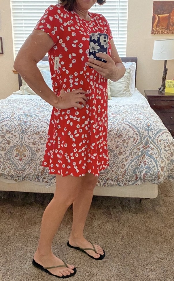 A reviewer wearing a red floral dress