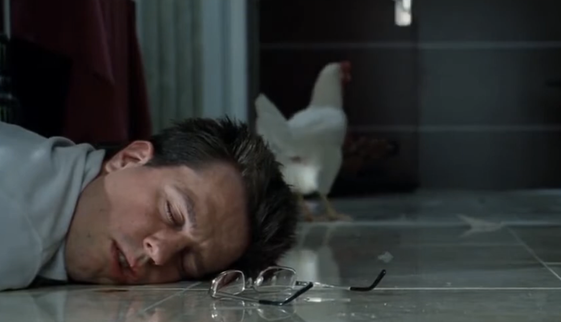 From &quot;The Hangover&quot;: A man is asleep on the floor with his glasses next to him and a random chicken behind him