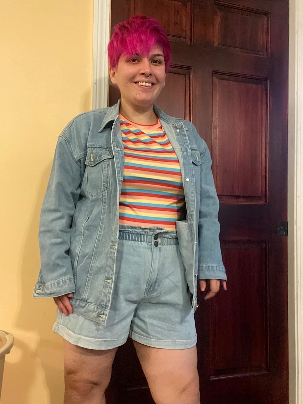 reviewer wearing the light blue wash denim jacket over a colorful pop