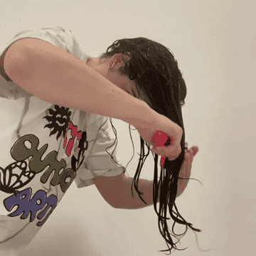 Claudia brushes her hair forward and away from her face