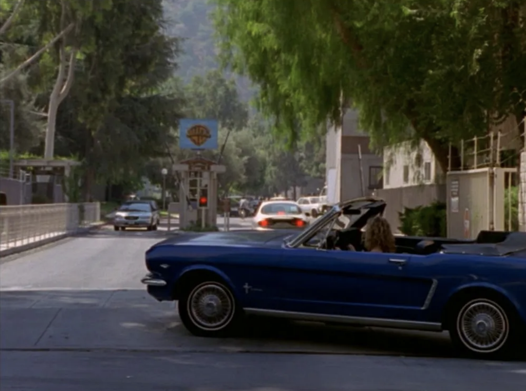 SJP driving a blue convertible