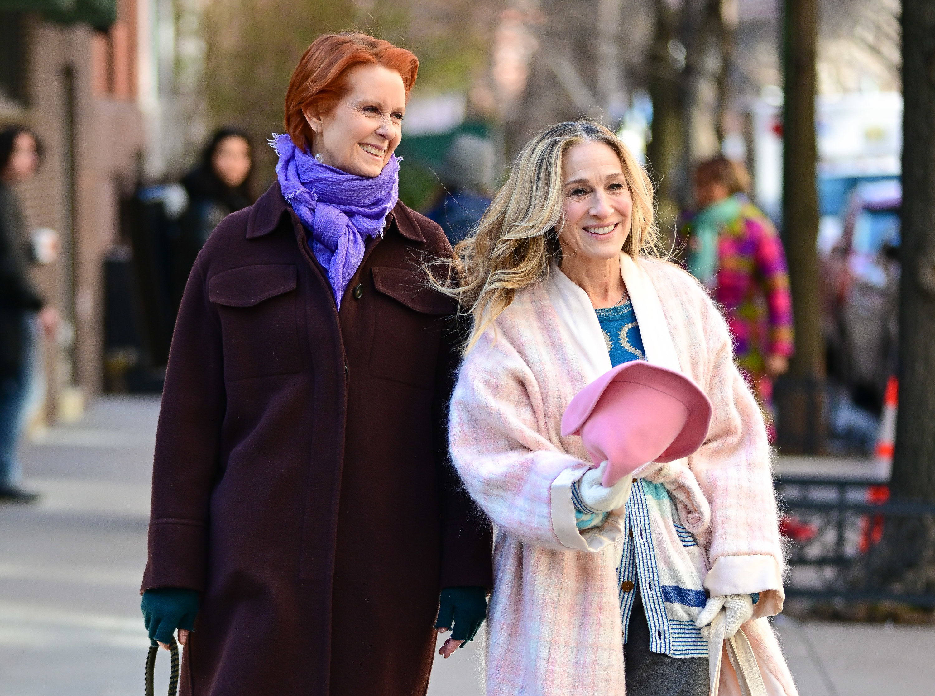 Miranda and Carrie wearing coats and walking on the street