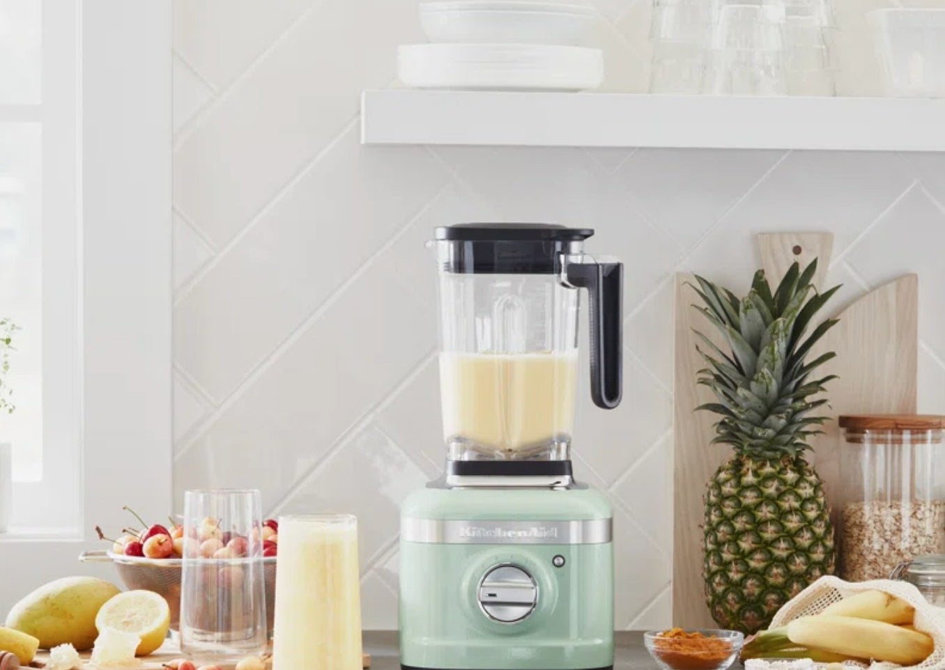 the light green blender on a counter with smoothie ingredients