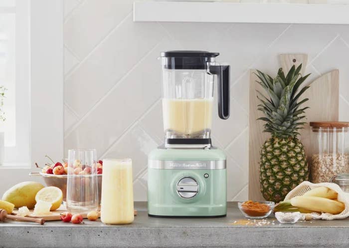 the light green blender on a counter with smoothie ingredients
