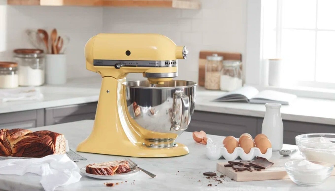 the yellow stand mixer on a counter surrounded by baking supplies