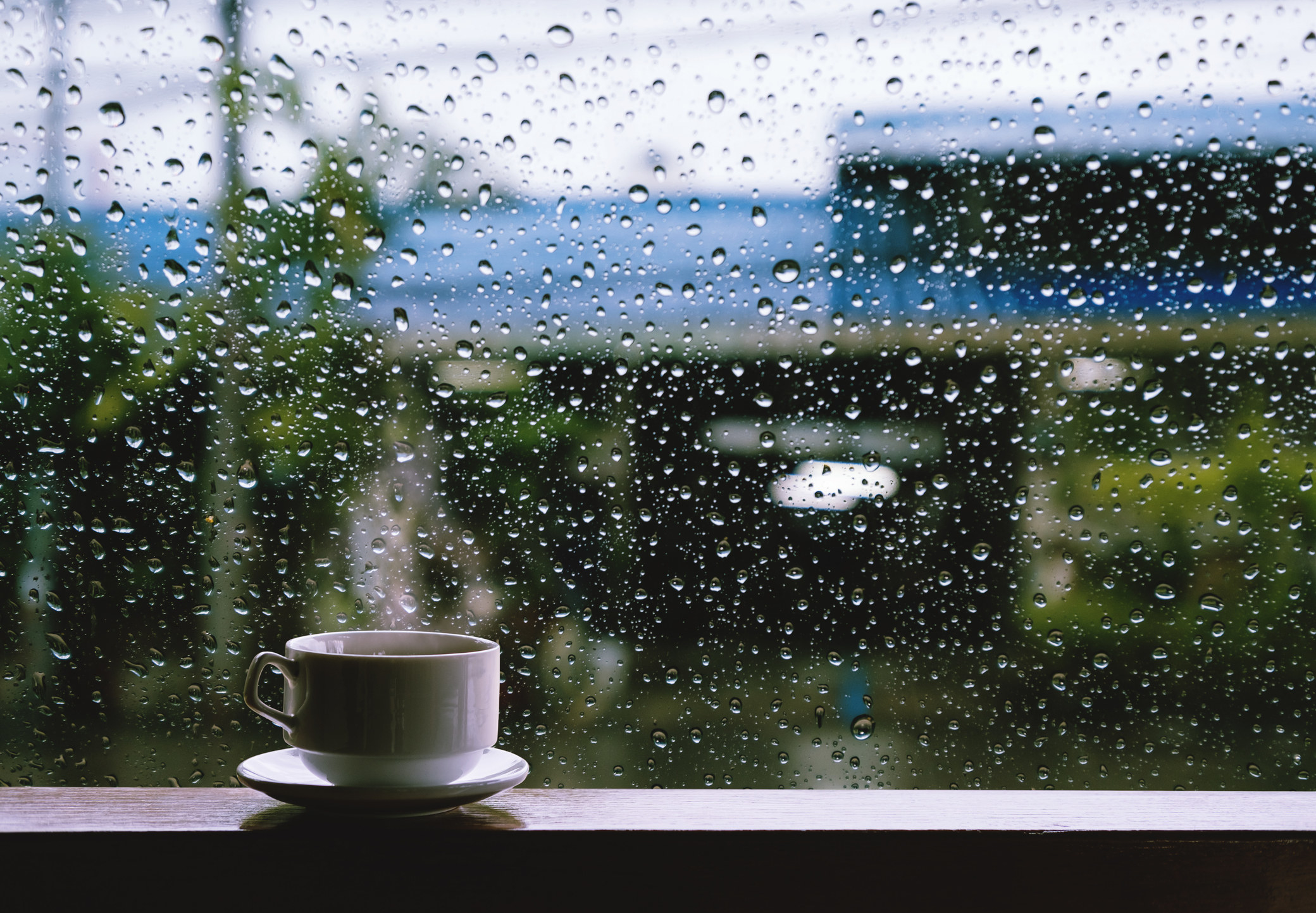 A hot coffee cup and a rainy window.