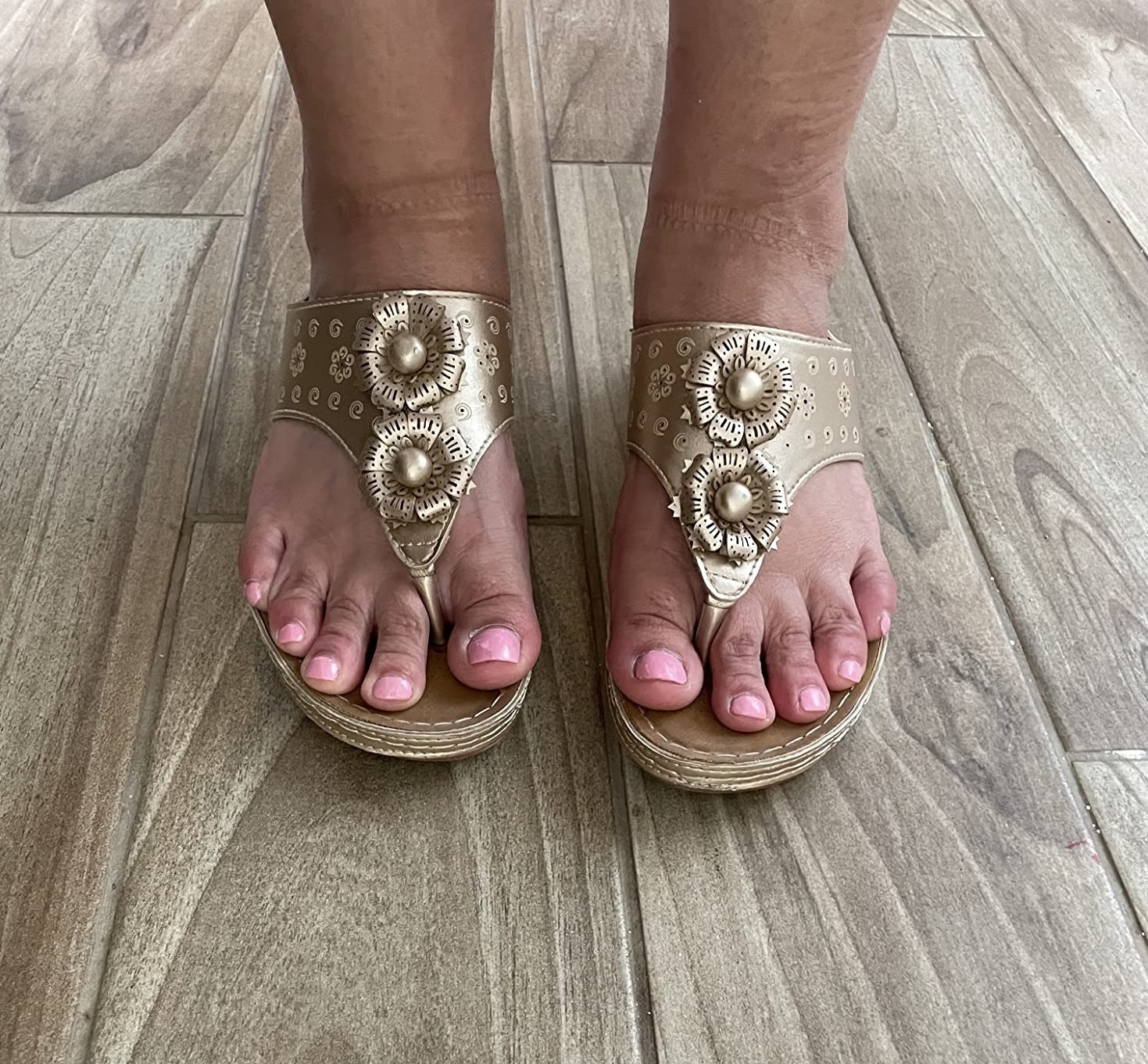 a reviewer wearing the gold sandals