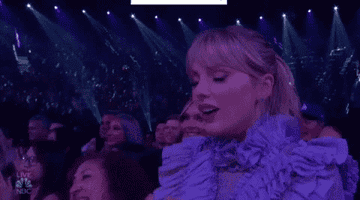 Taylor Swift letting out a breath and smiling