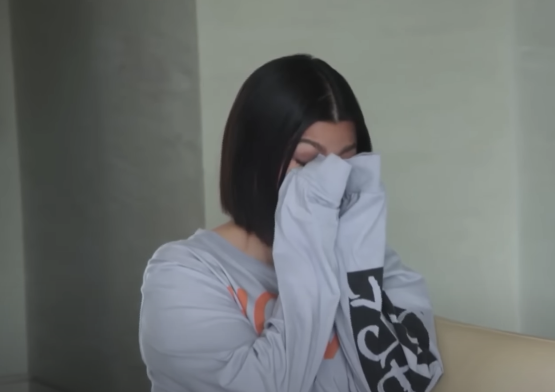 Closeup of Kourtney crying and wiping her tears