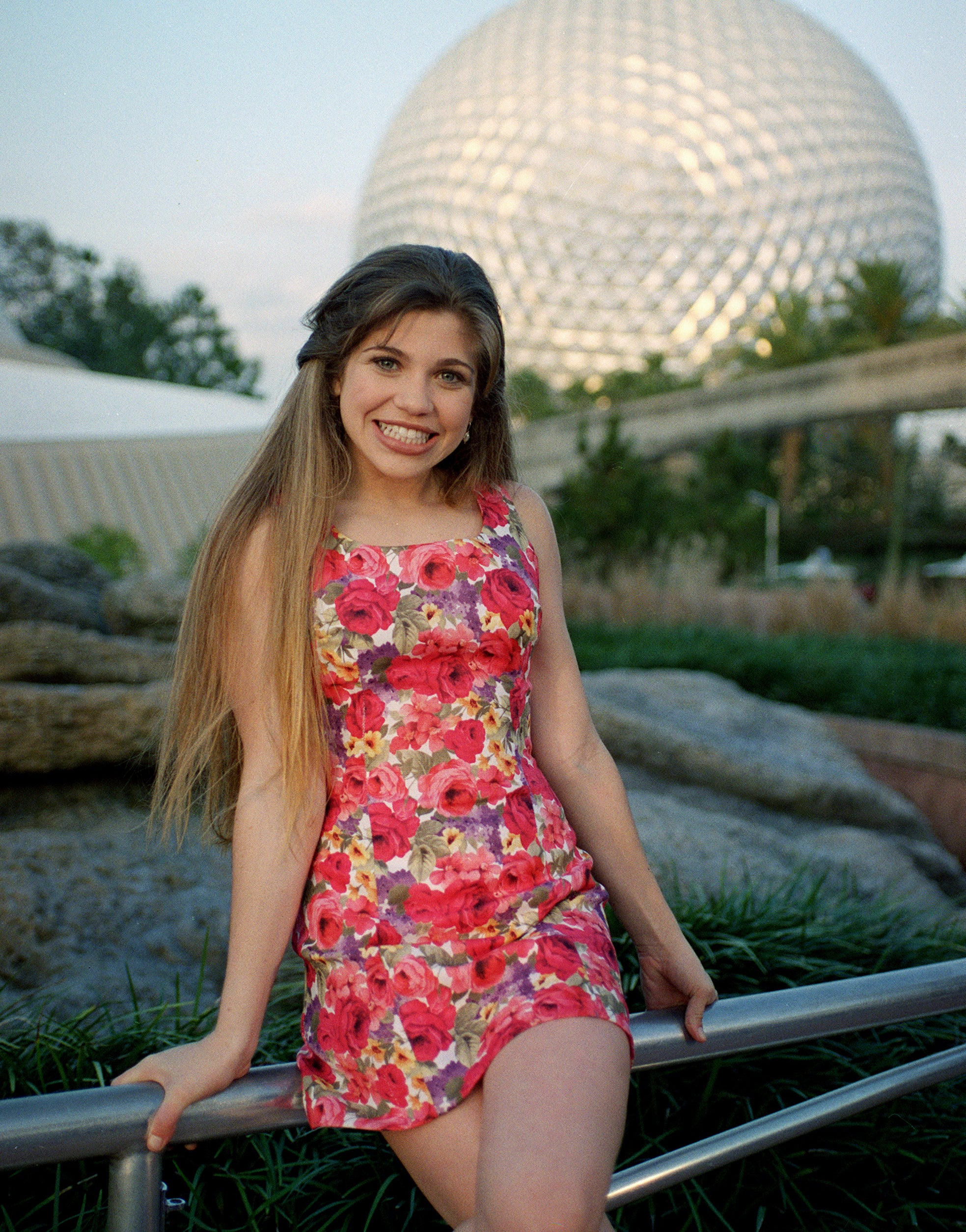 Danielle smiling and wearing a floral minidress