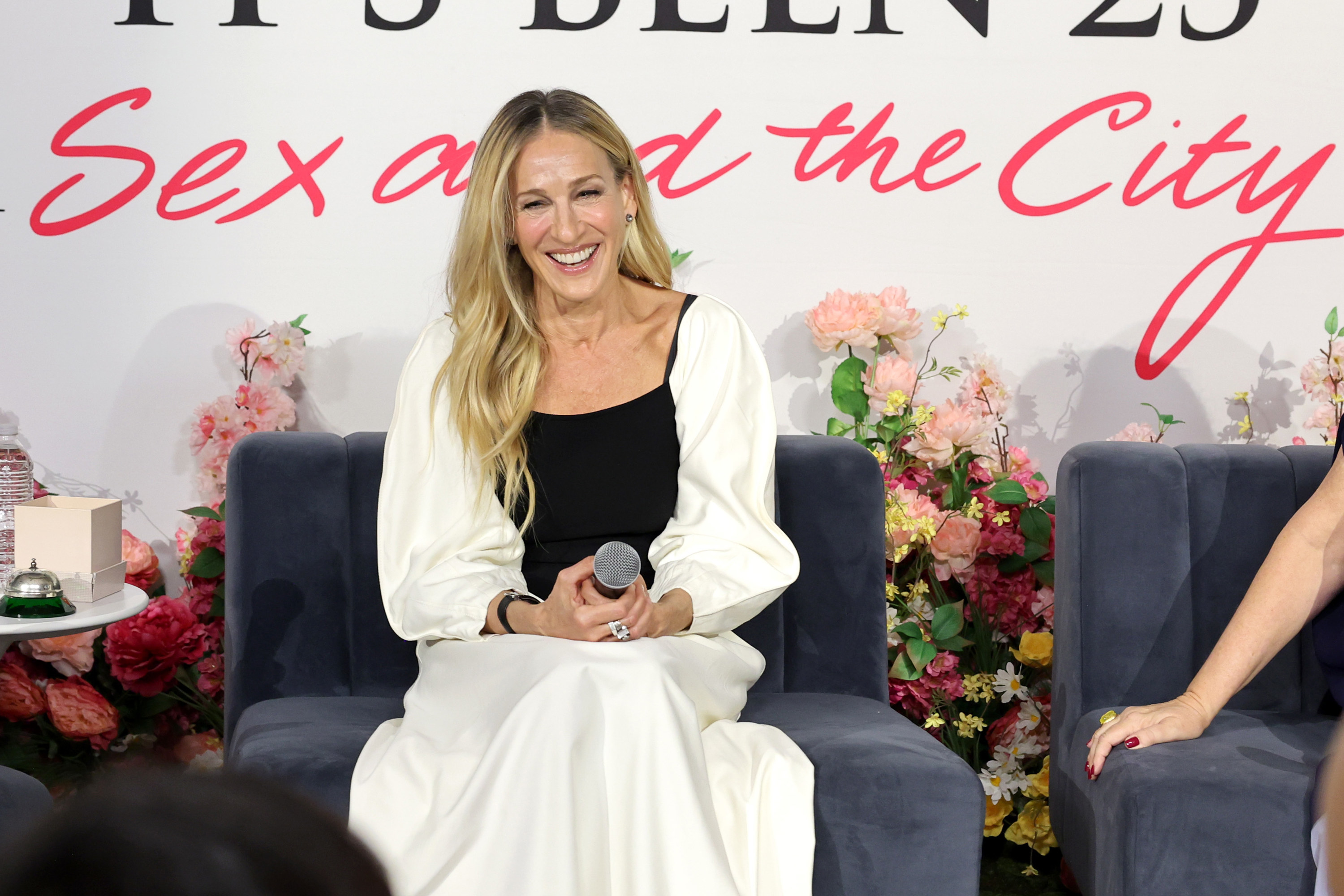 Close-up of SJP smiling and seated