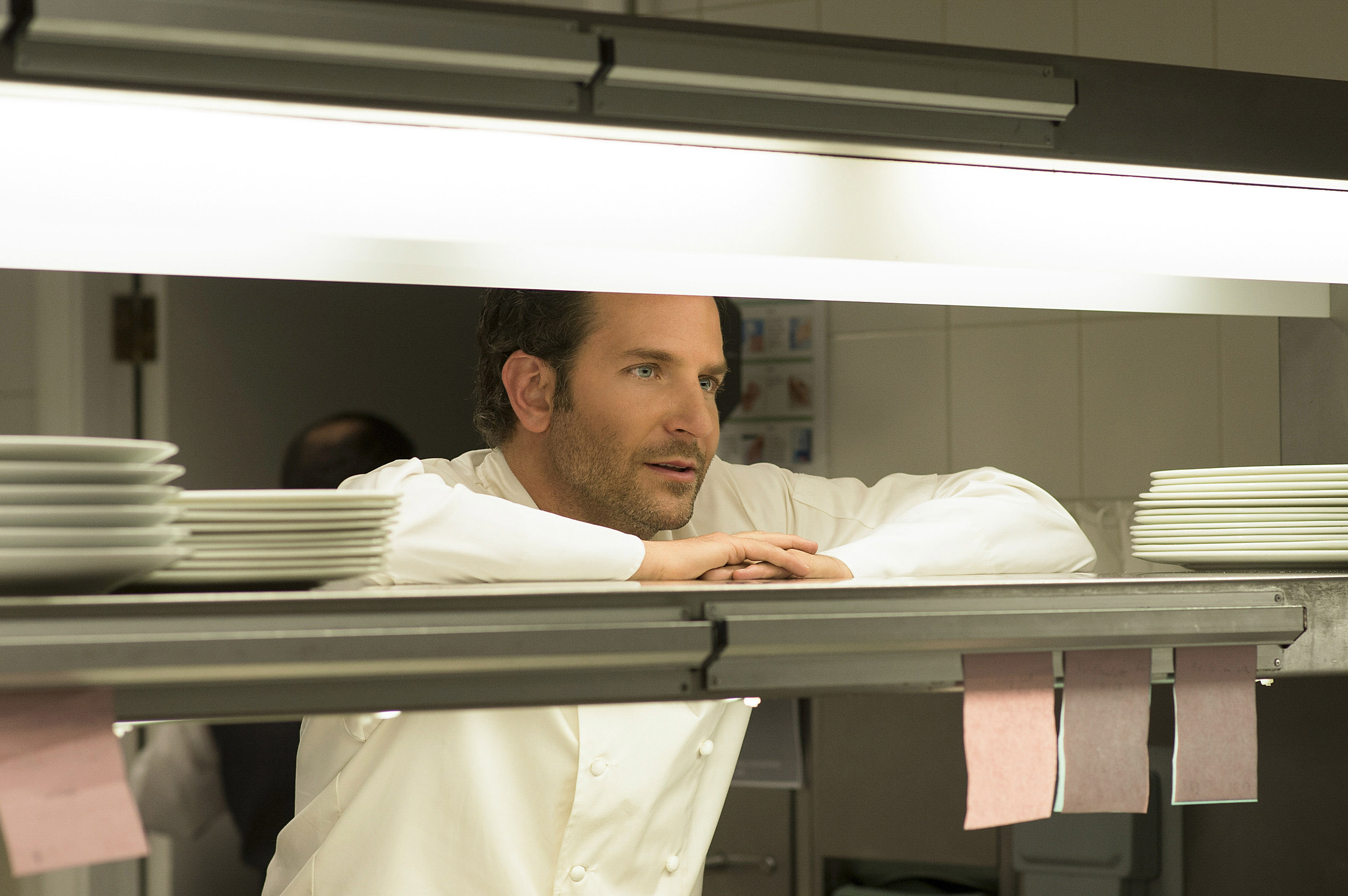 Bradley Cooper dressed as a chef in a kitchen in Burnt