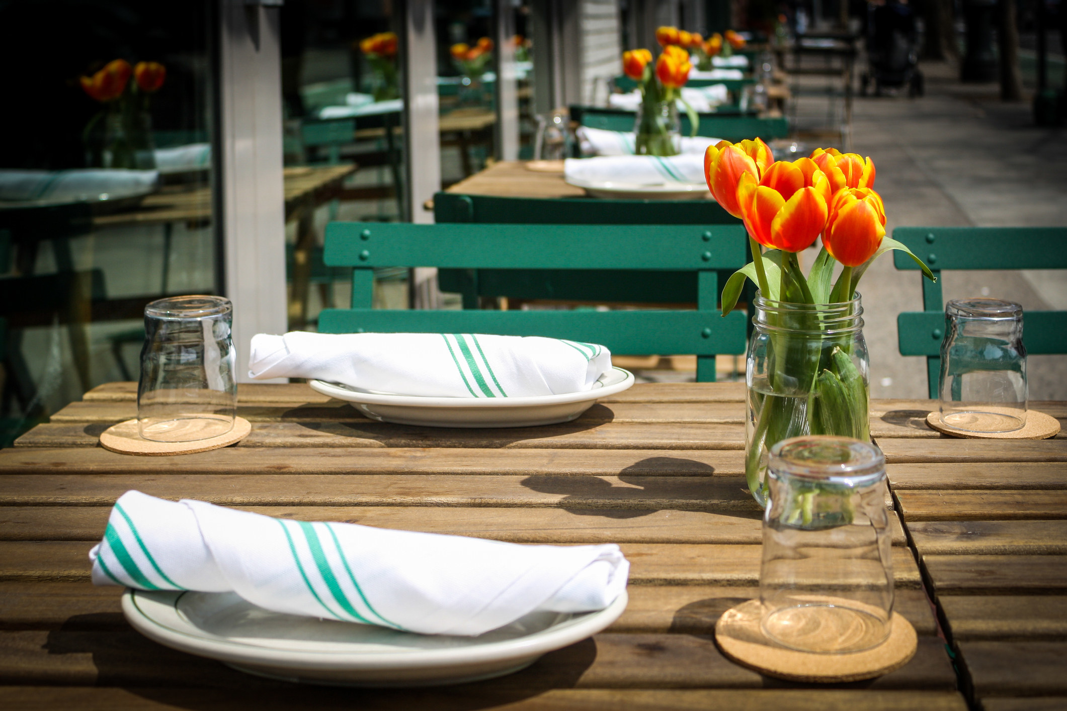 Place setting with tulips at sidewalk cafe.