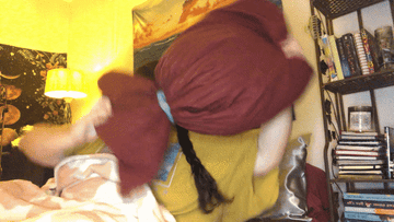 woman putting pillow over face and laying down