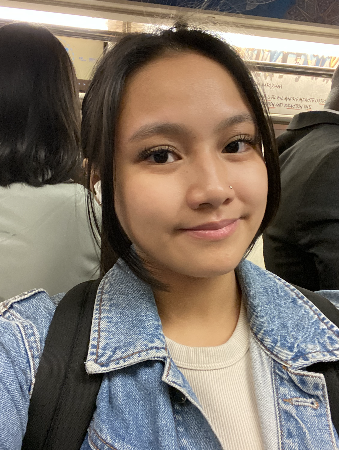 selfie of girl wearing makeup while on a crowded train