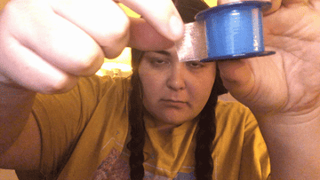 woman ripping piece of tape off of tape roll