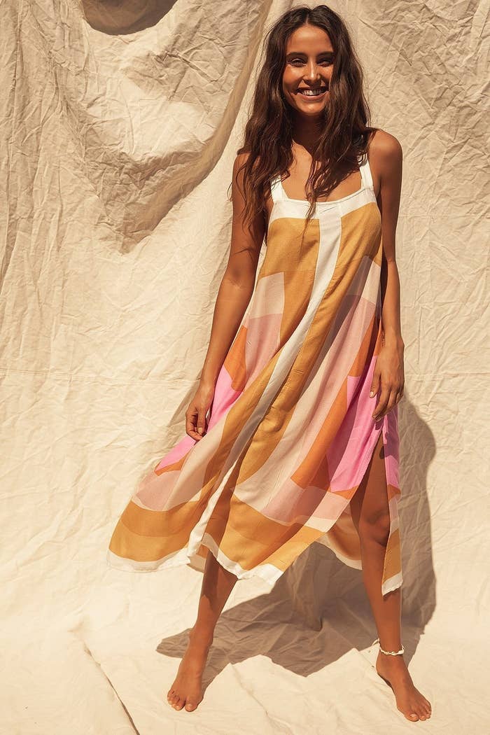 Model wearing loose fit dress with orange, pink, and white geometric pattern