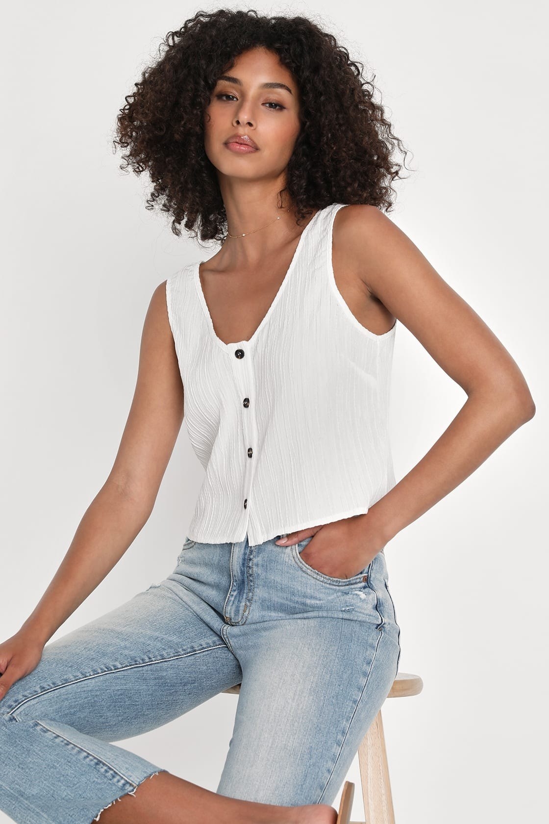 Model wearing white button down crop top with jeans