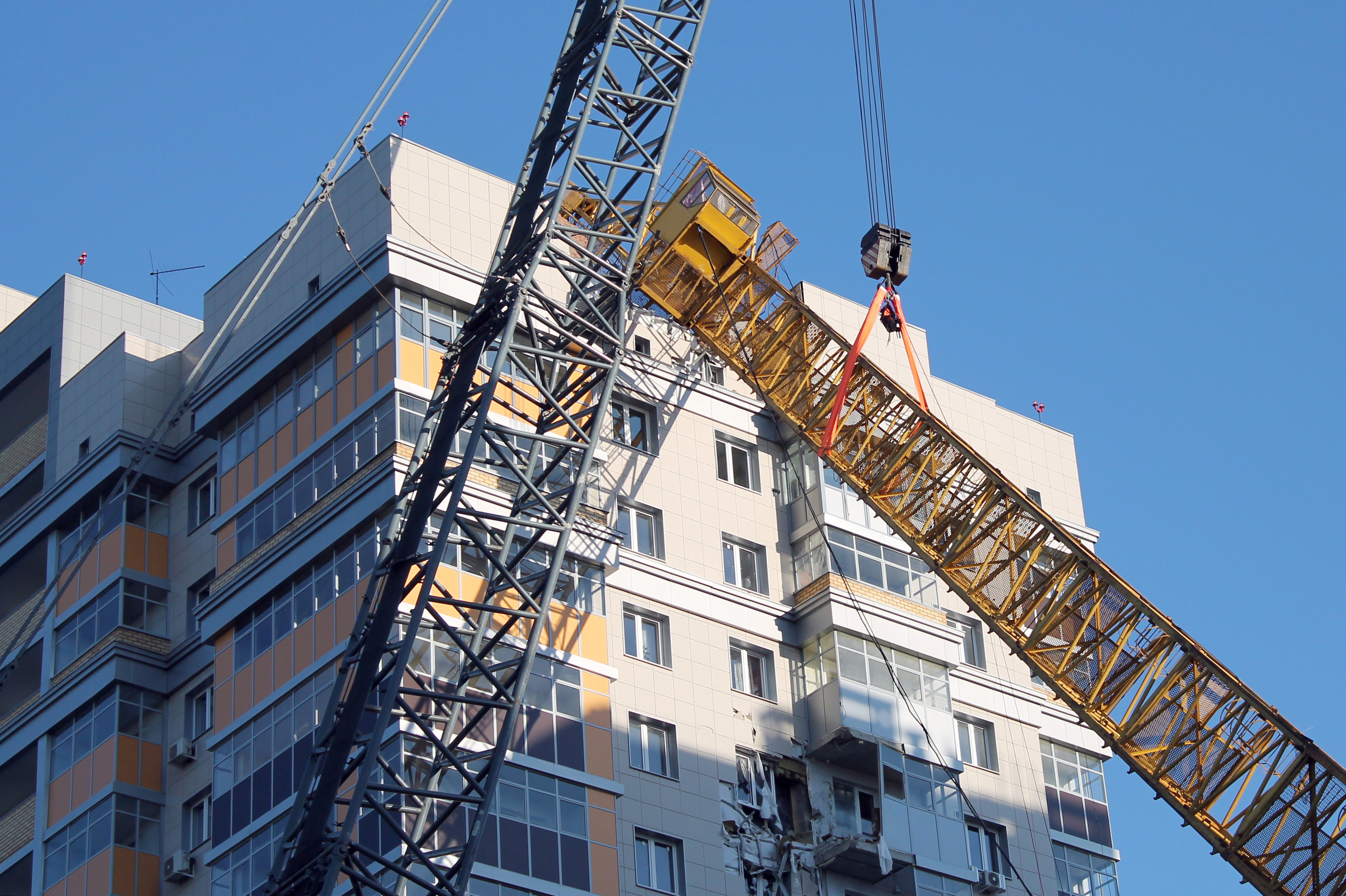 Large crane fallen from a tall building roof