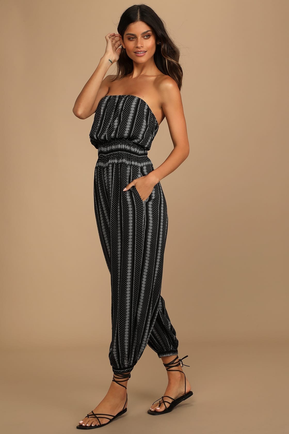 Model wearing black and white patterned tube top jumpsuit
