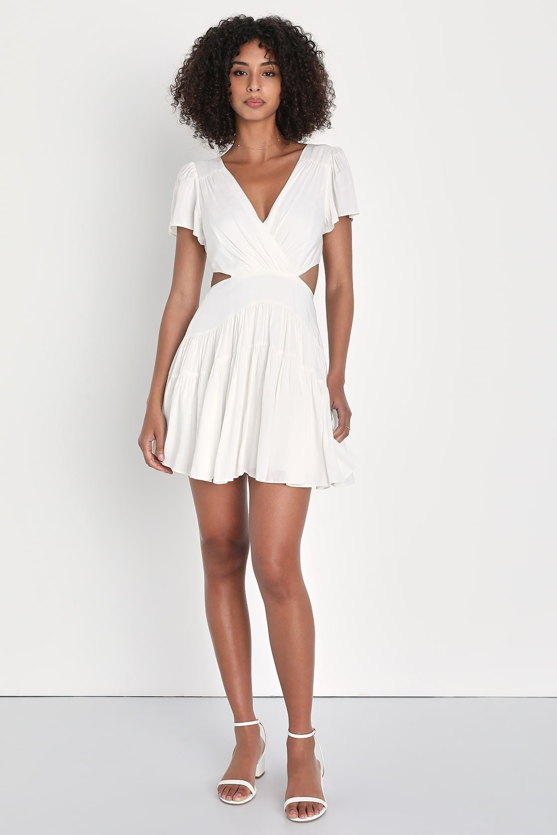 Model wearing white cut-out flutter sleeve mini dress