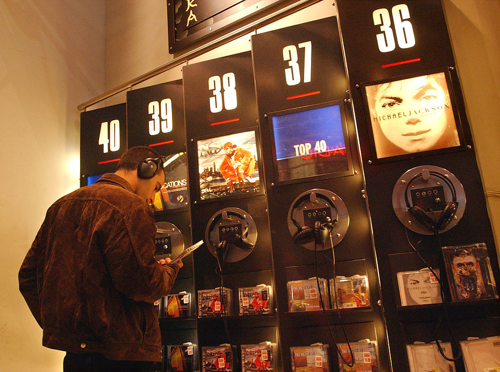 A man listening to a CD at a kiosk