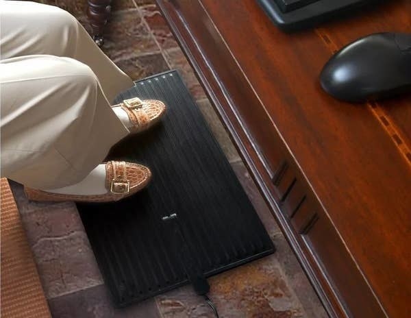 The heated mat under the user&#x27;s feet at a desk