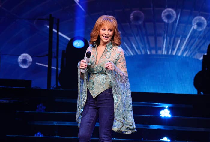 Reba holding a mic on stage