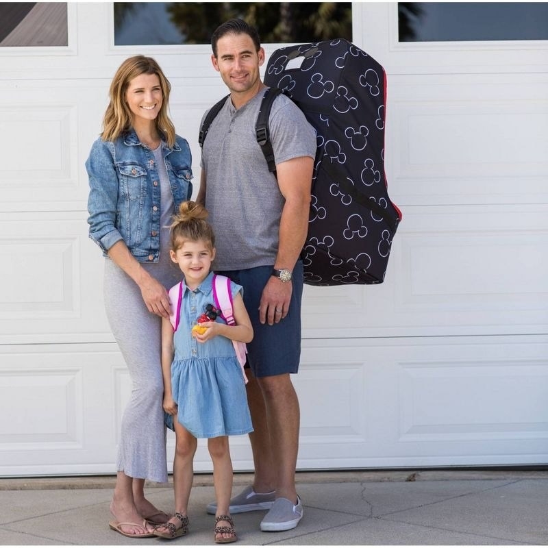 Model family poses while one model carries the car seat in the bag