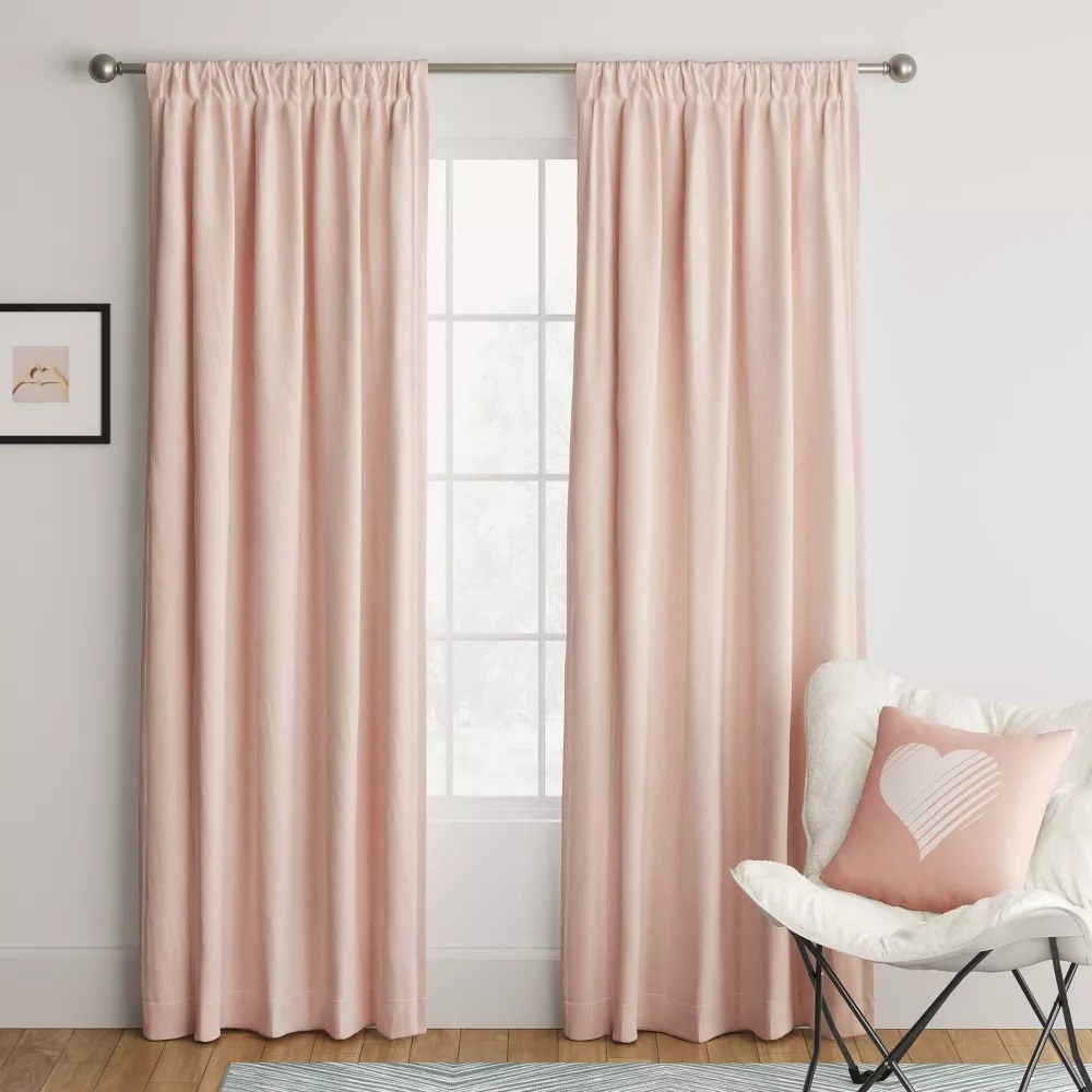 two of the heathered curtain panels hanging on either side of a window in a room