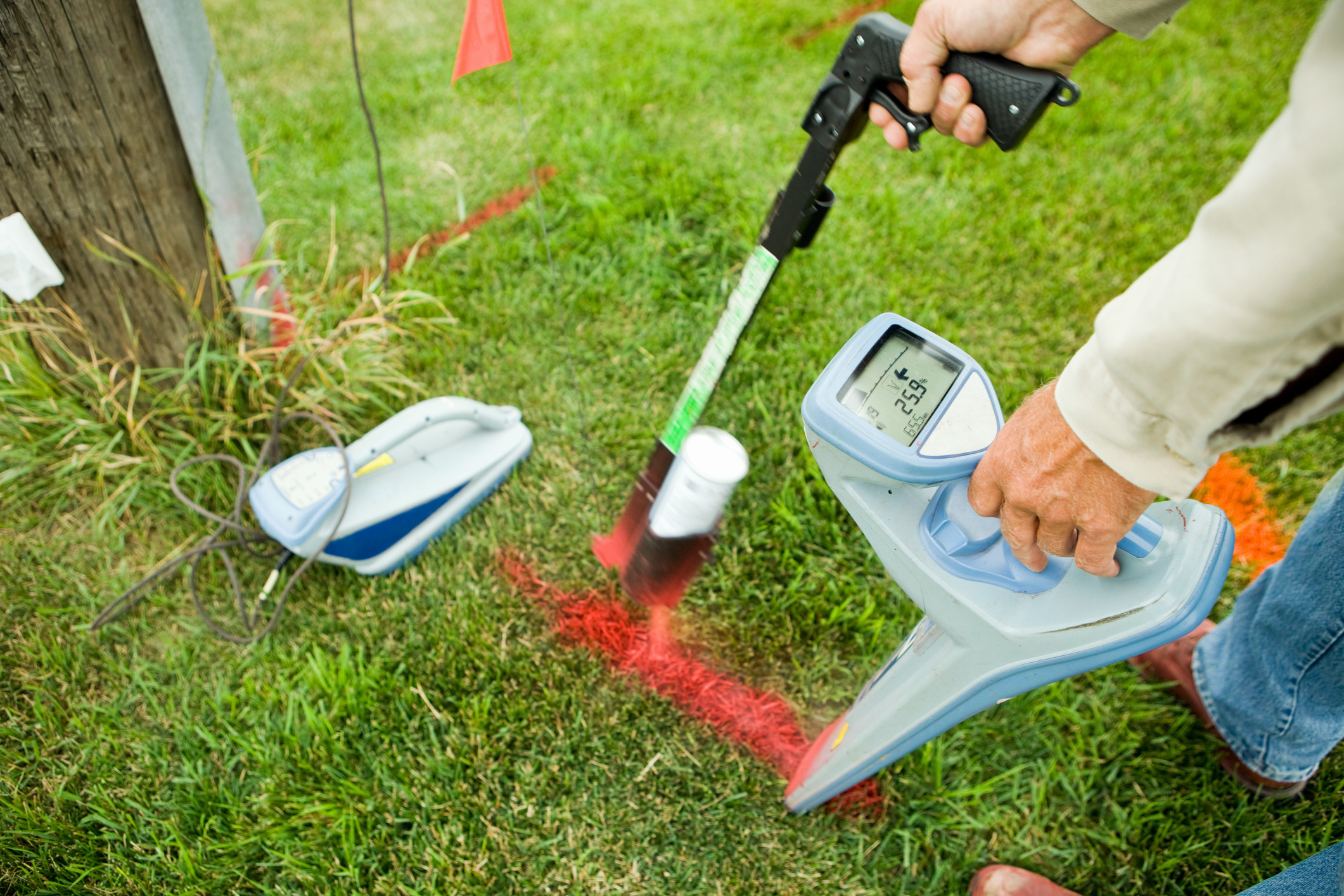 A person using a machine on their grass to locate utilities