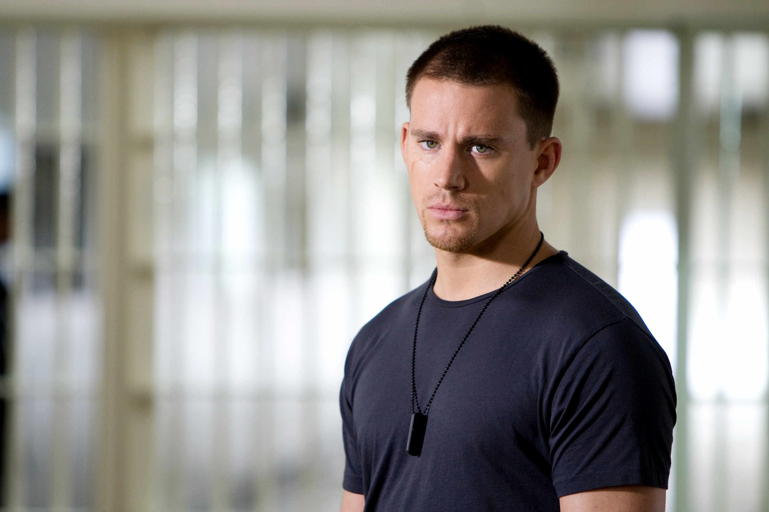 Channing Tatum, wearing dogtags, scowls in a prison cell