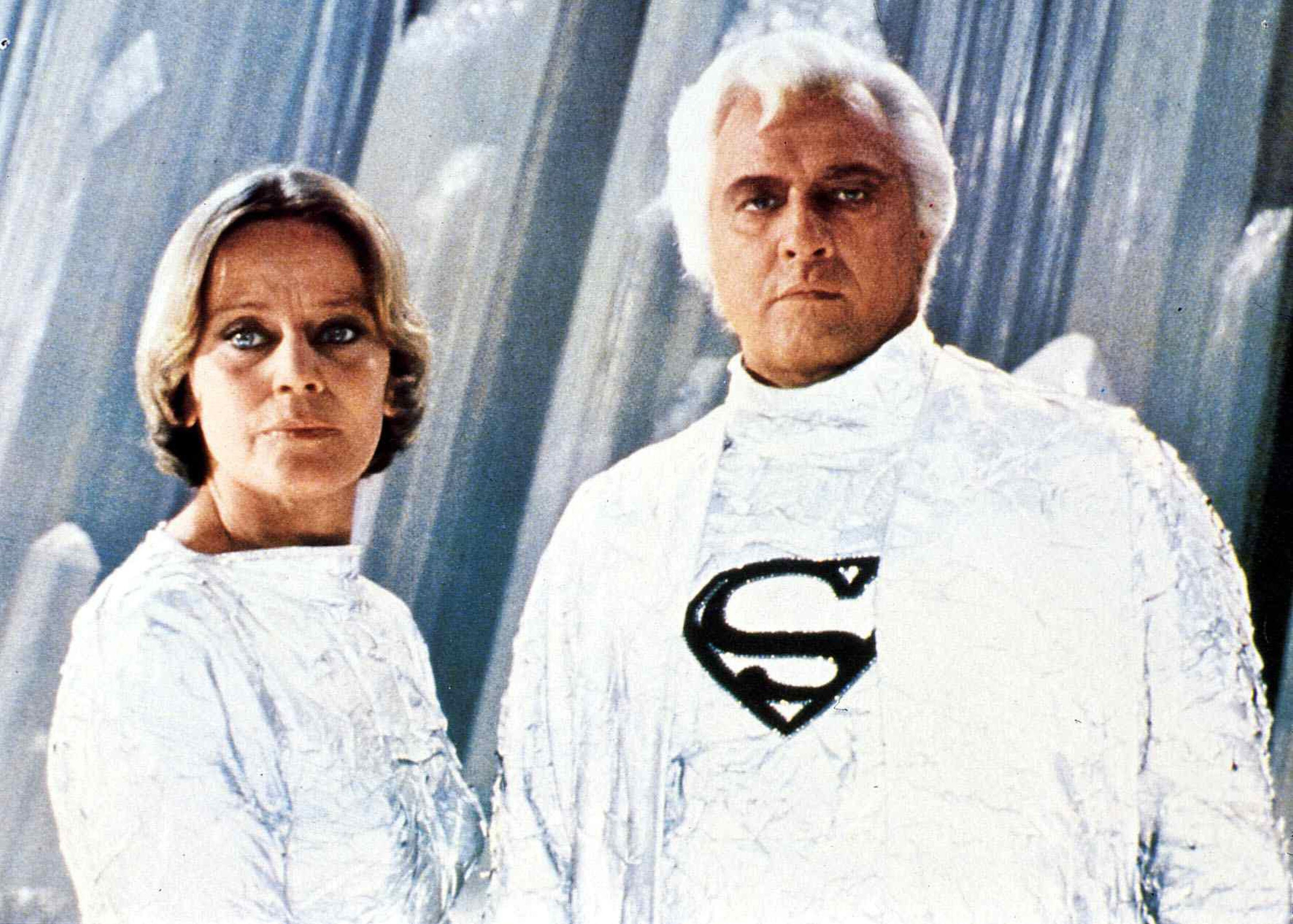 Marlon Brando stares ominously in an ornate white suit with an S-logo