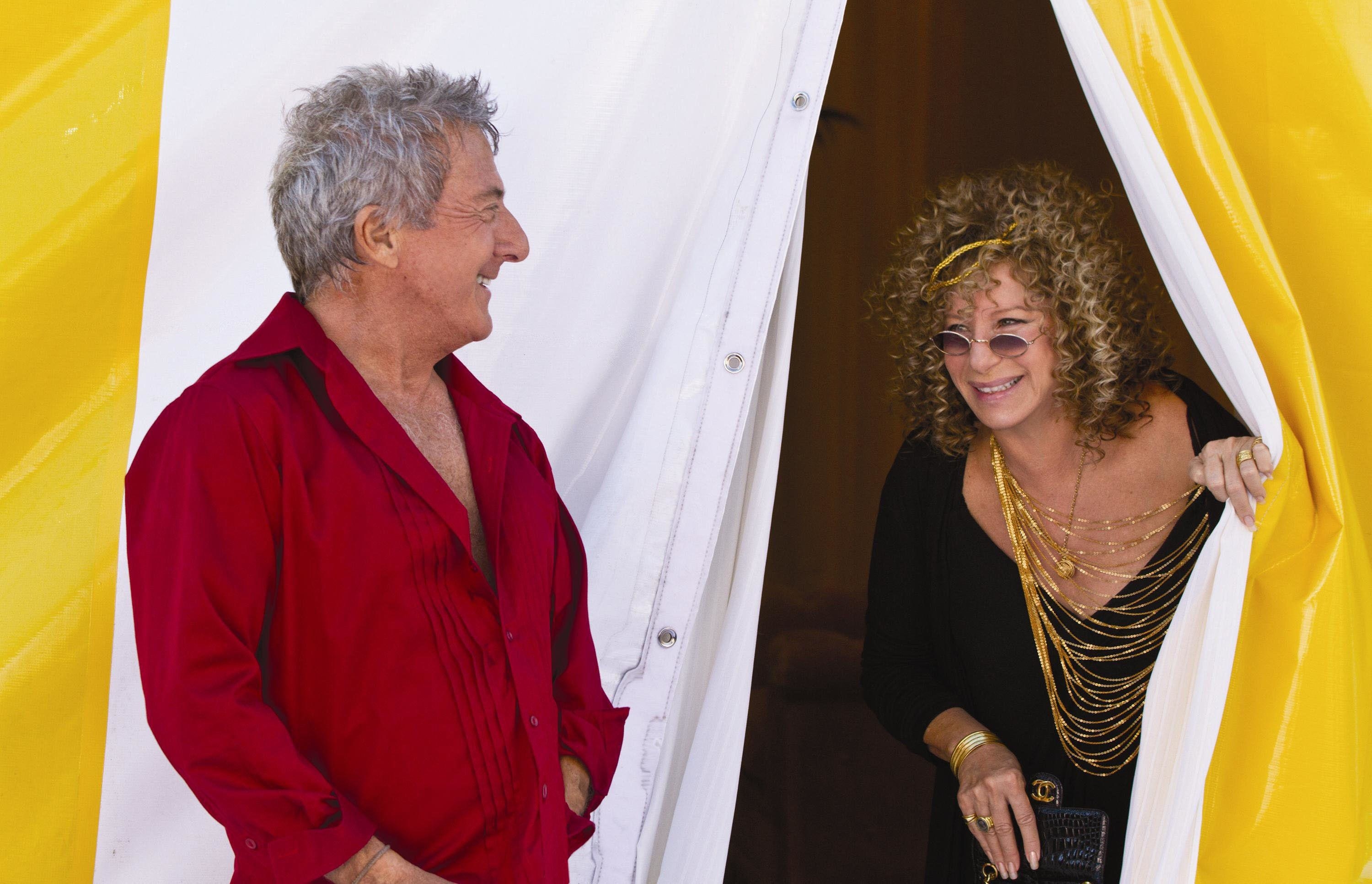 Dustin Hoffman and Barbara Streisand smile at one another near a tent