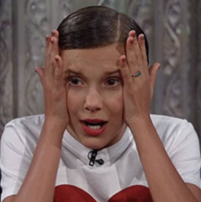 Millie Bobby Brown with her head in her hands in shock