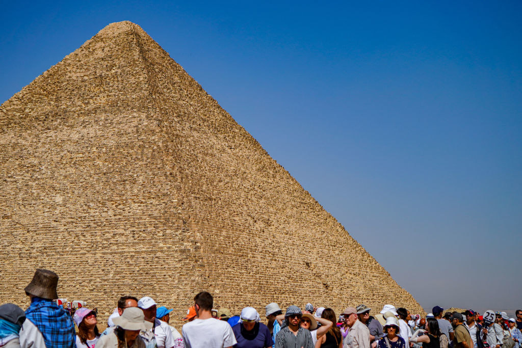 A crowd of tourists outside one of the Pyramids of Giza