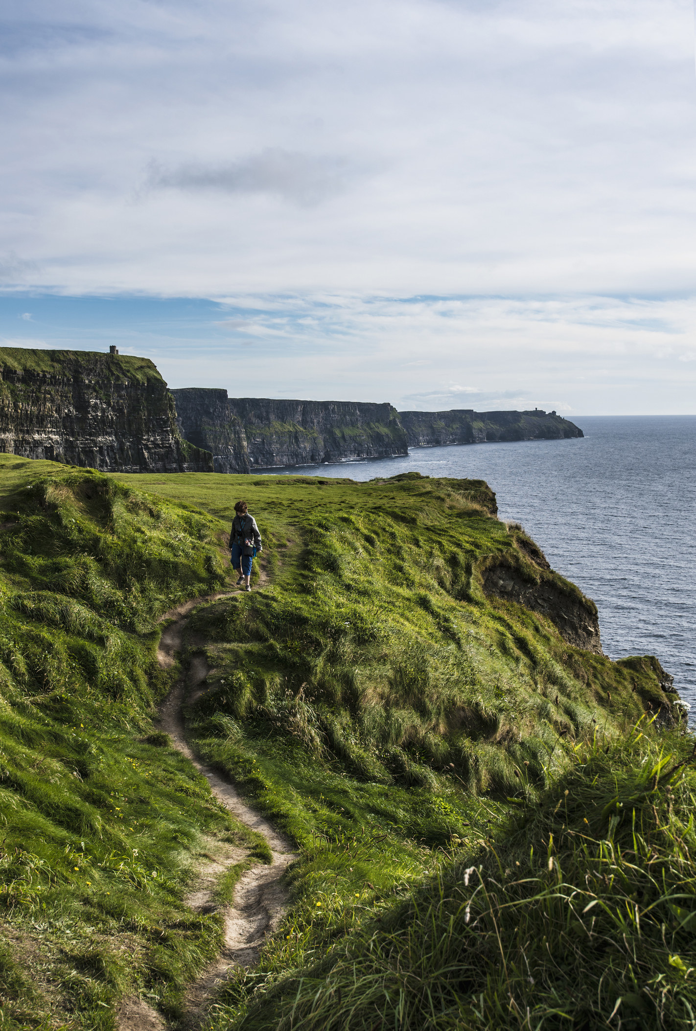 A woman walking along the Cliffs of Moher