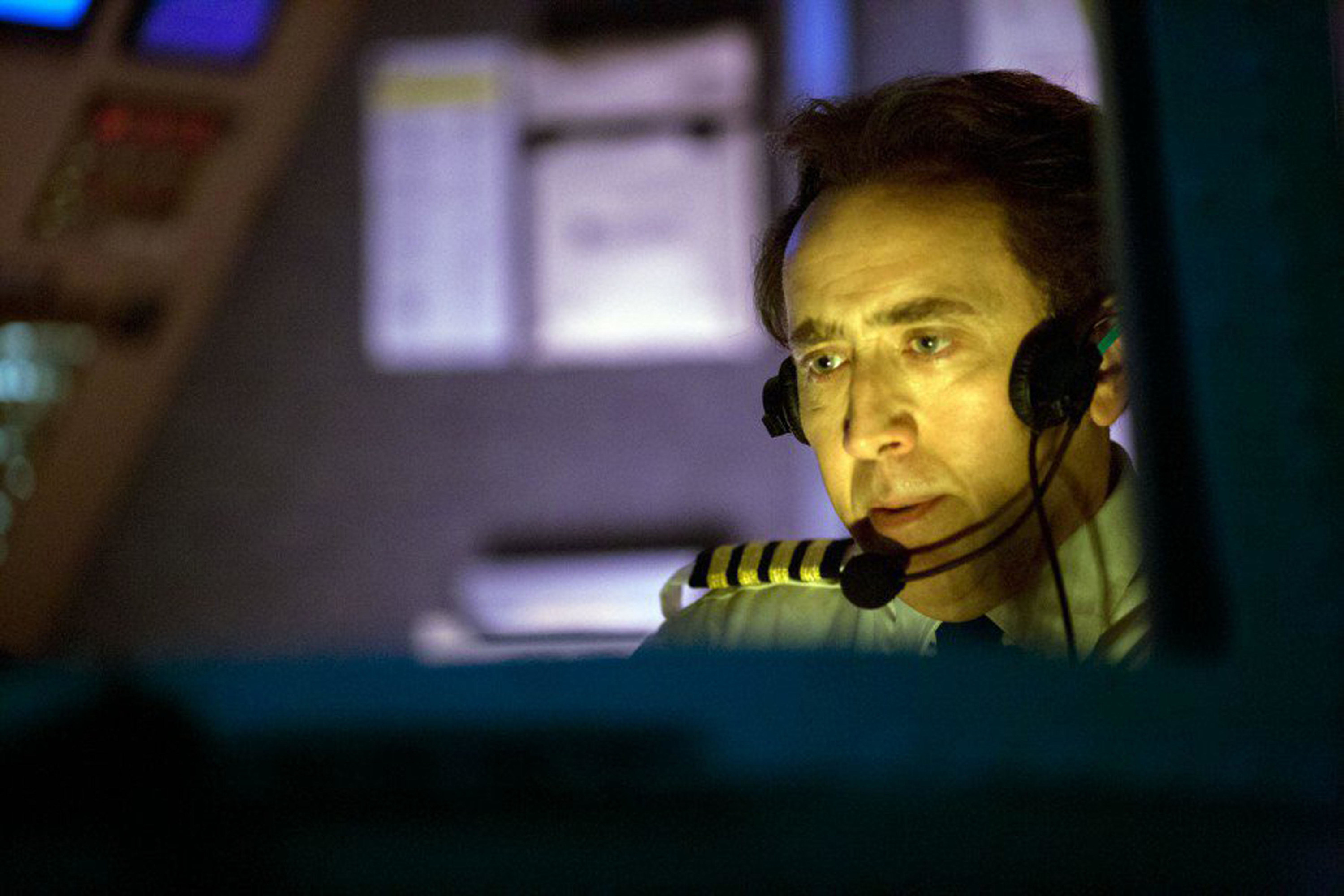 Nicolas Cage sits in an airplane cockpit