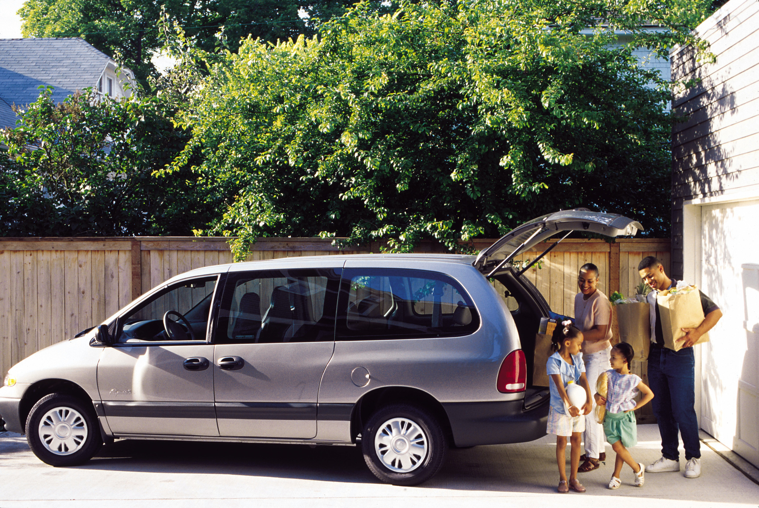 family unloading groceries from a minivan