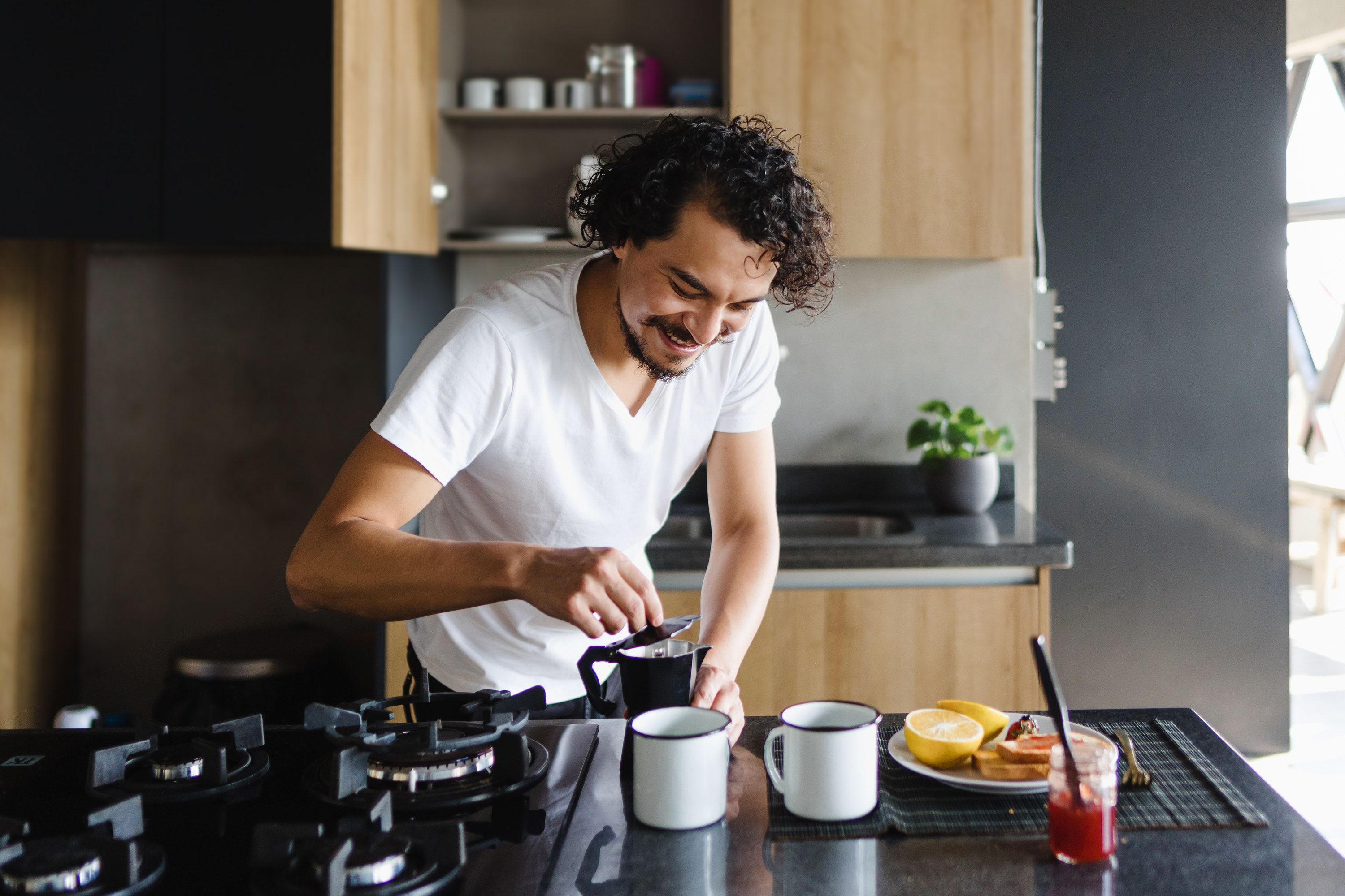 A man gets coffee ready with his breakfast in the kitchen