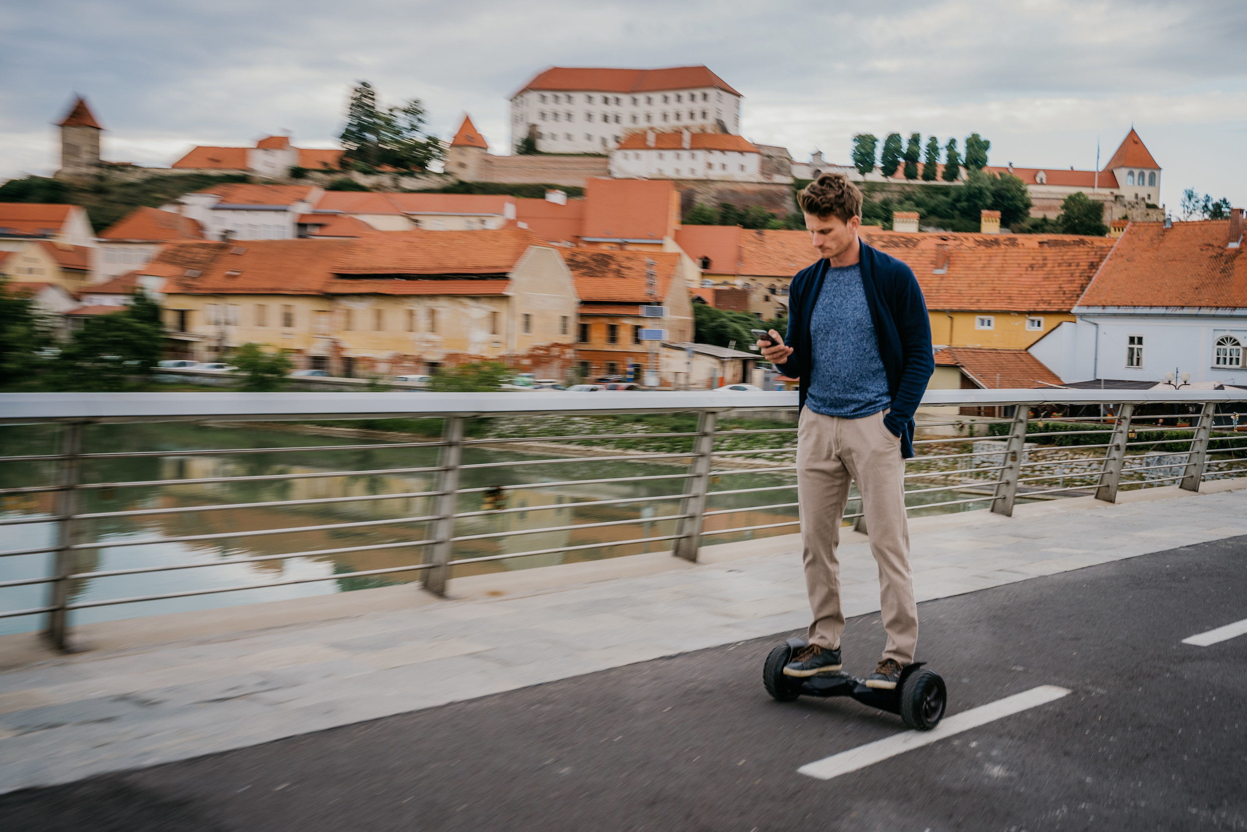 A man on his phone while riding a hoverboard