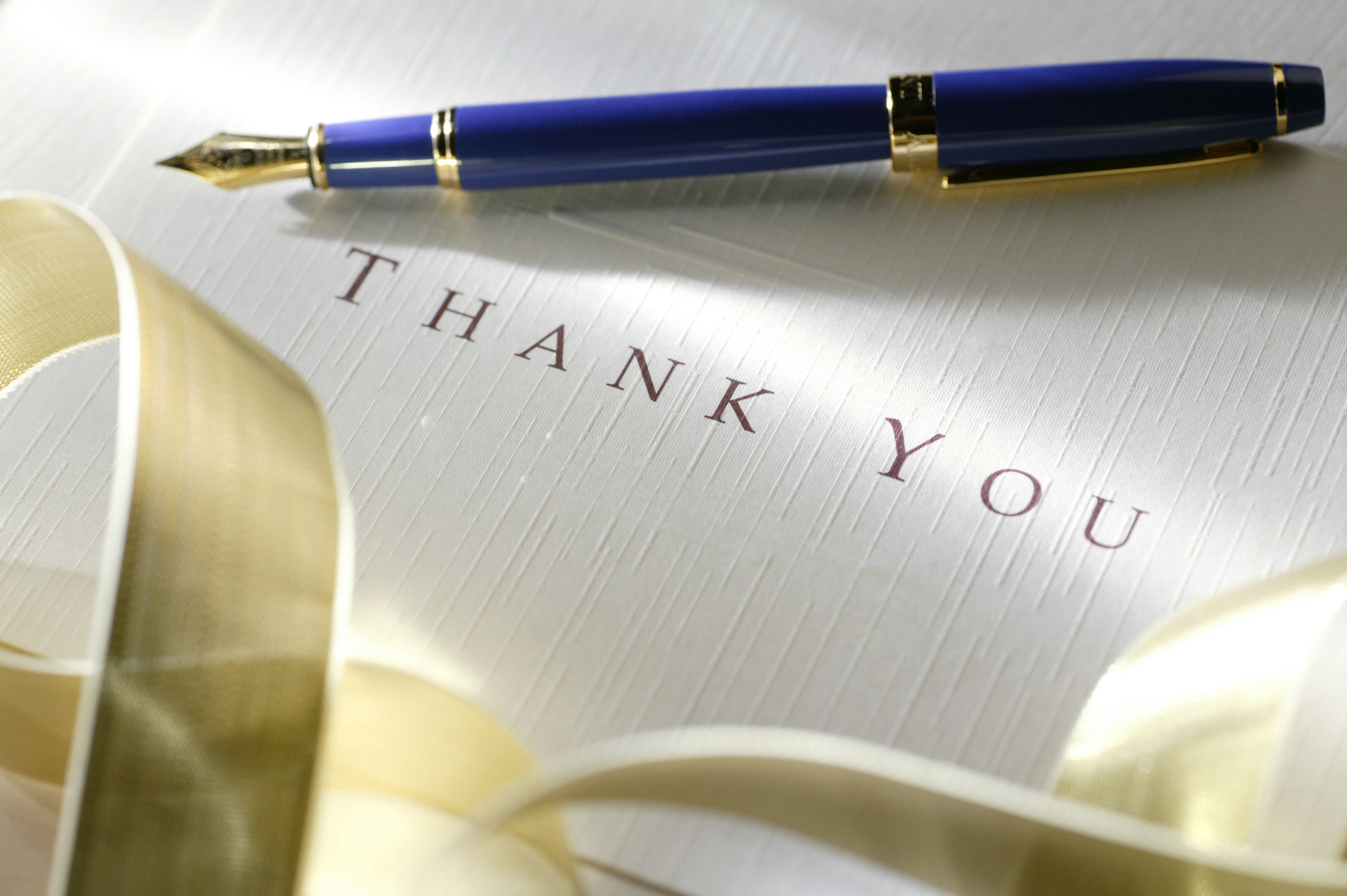 A thank you note with a pen laying on it
